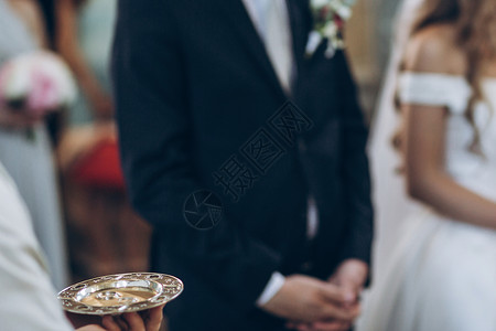 结婚戒指在教堂的金盘上神圣的婚姻婚图片