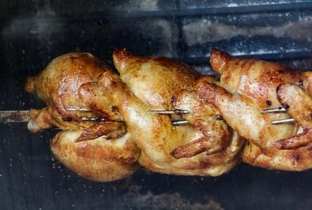 三只鸡在烤肉架上烤背景图片