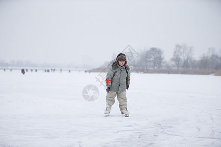 一个小孩在大雪覆盖的湖上滑图片