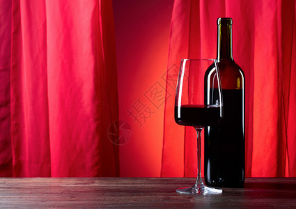 红背景的眼镜和酒瓶子复制空图片