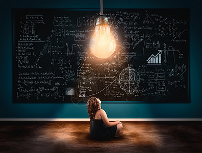 年轻女孩在黑板前看着灯泡满是公式的黑板上解决数学公式的概念图片