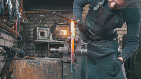 用铁锤制成热钢的距离越远铸铁架上高清图片