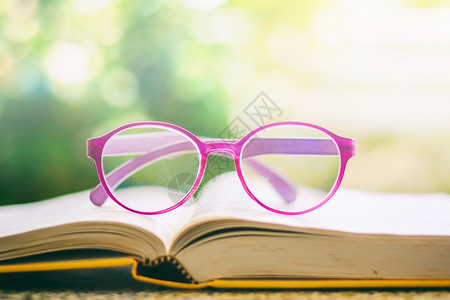 眼镜放在一本打开的书上图片