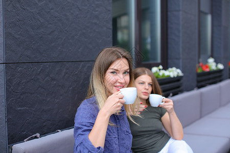 美丽的妇女在咖啡馆喝咖啡和休息图片