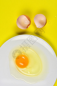 在黄色背景的破裂的鸡蛋图片