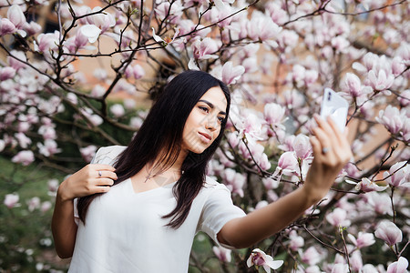 美丽的时尚的caucasian女人在花朵木图片