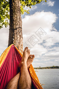 在树下海滩的吊床上放松背景图片