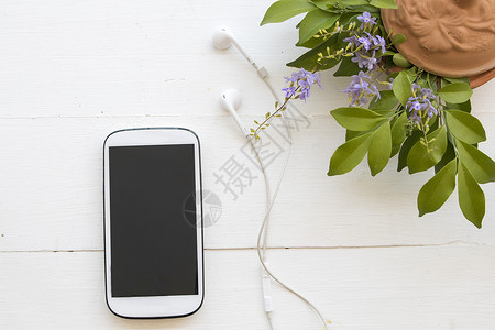带耳机的手机背景为白色的花朵图片