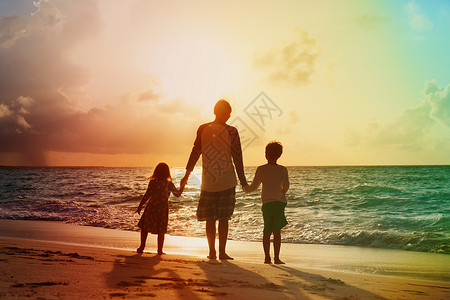 父亲和两个孩子的儿子和女儿在日落时图片