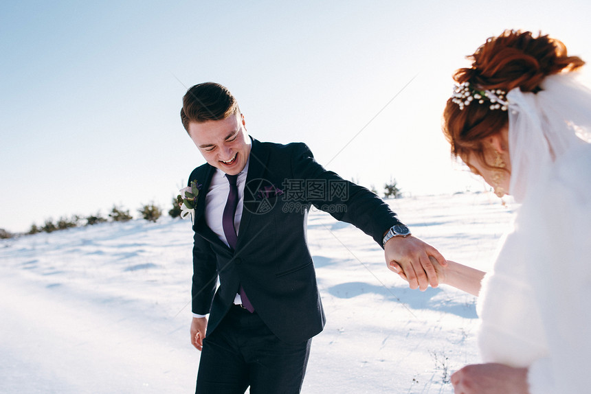 新娘与新郎在草地上散步在冬日手牵图片