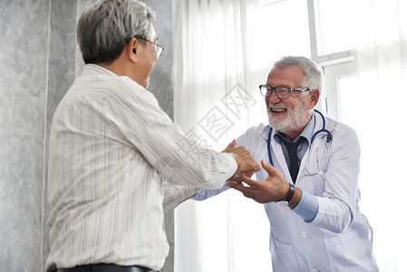 幸福的人高级男医生和亚洲男病人一起在医疗室背景图片