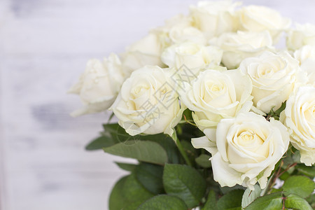 别致的白玫瑰花束花瓶里有叶子图片