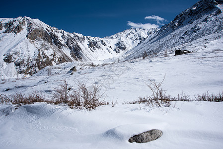 高山在寒冬雪下的高山下阳光明媚图片