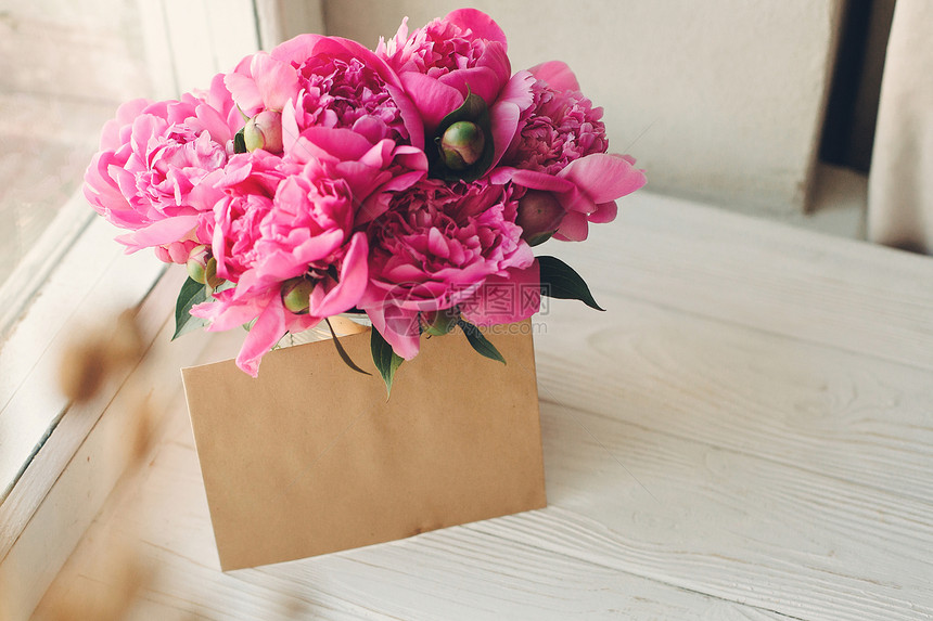 浪漫的粉红花束用粗制白木背景图片