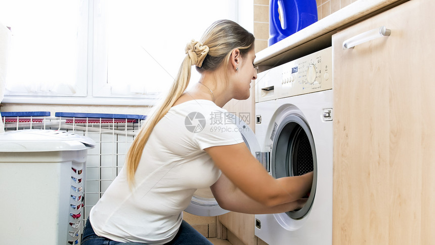 金发女人从洗衣机里拿出湿衣服图片