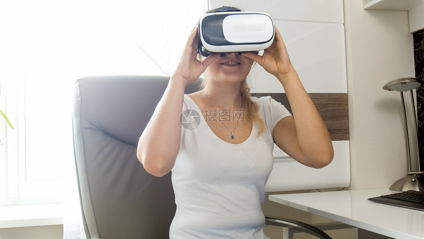 坐在皮椅上并使用VR头盔的图片