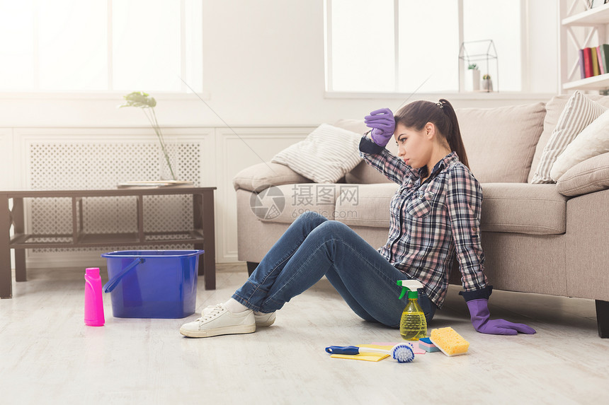 疲累的女士用许多工具打扫地板年轻疲累的女孩对清洁剂的数量感到惊图片