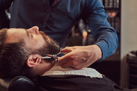 专业理发师在理发店用剪刀和梳子做胡须模特图片