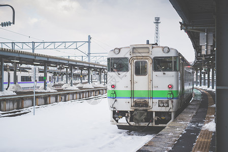 冬天下雪的火车站上的当地火车图片
