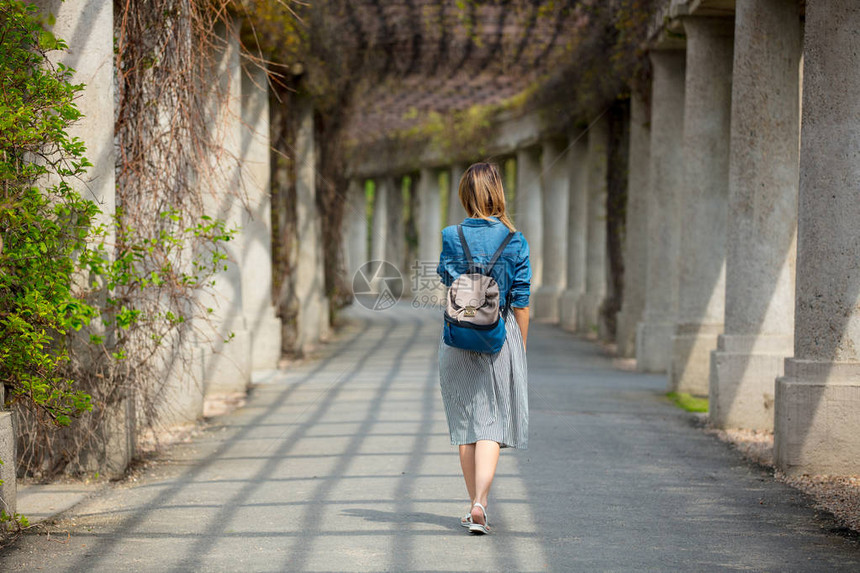 背着包的少女在波兰罗克拉夫与拱门和柱子同巷图片
