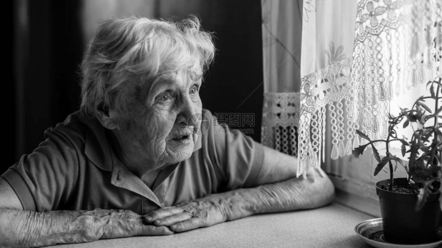 年长的老妇人看着窗图片