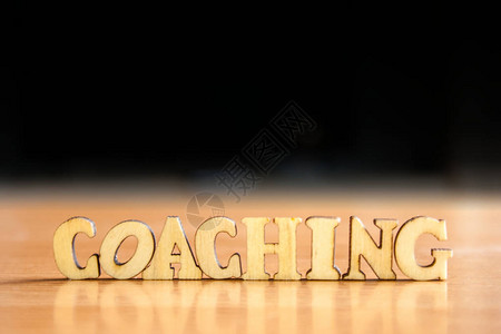 木制字母的coaching一词木刻在桌子上图片