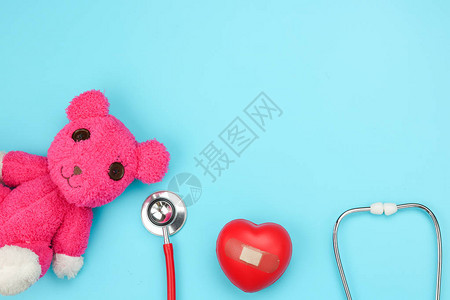 蓝色背景中的听诊器红心和熊红心图片