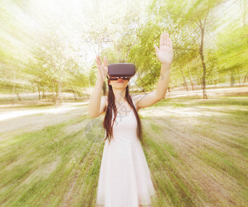 身着虚拟现实眼镜户外自然和技术的有背景图片