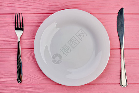桌子上的盘子叉子和刀带白板银叉和刀的粉红色纹理图片