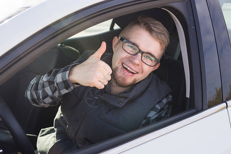 年轻人试驾新车并竖起大拇指图片