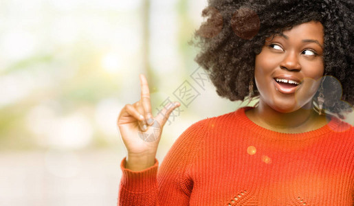 美丽的非洲女人用手指对着背景图片