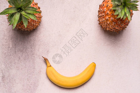 菠萝和香蕉排列在微笑的脸上图片