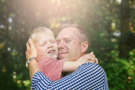父亲和儿子在花园里拥抱并微笑男观图片