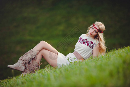 温柔的金发女人坐在草地上图片