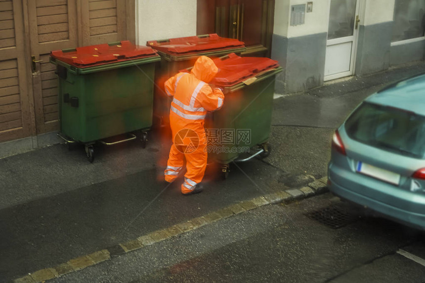 男工人身穿橙色制服在雨季与尘石一图片