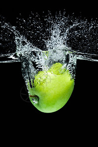 绿苹果掉入黑漆的水中紧图片