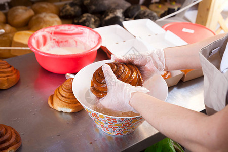 一名身戴保护手套的女面包师在面包店为她们准备包肉图片