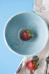 蓝色深蓝色板块中的红色多汁草莓图片