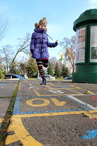 一个小女孩在户外单腿跳图片