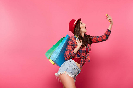 在粉红背景购物和折扣概念下使用移动电话图片
