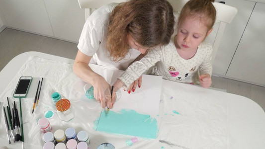 母亲和孩子用彩色刷子画儿童游戏会影响早期儿童的图片