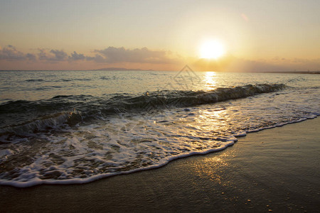 一个金色的日出海浪和沙图片