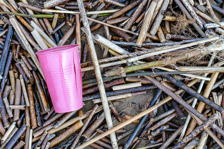 扔在地上的粉红色塑料杯乱扔垃圾的概念图片