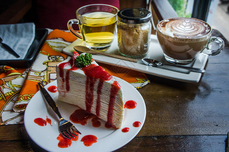 咖啡店木桌上的草莓大便蛋糕图片