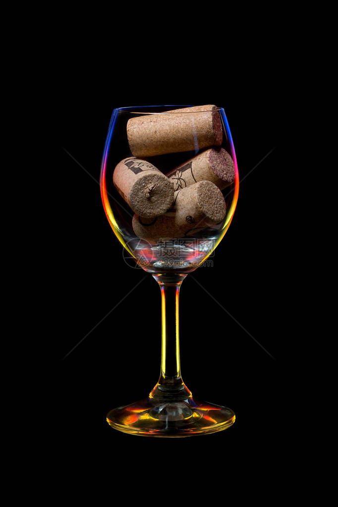彩色光照亮的葡萄酒玻璃充满黑色背景的图片