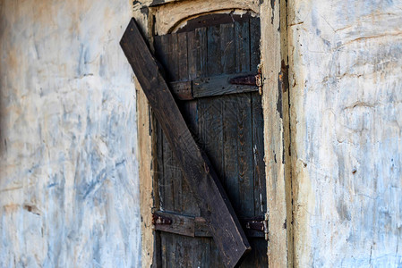 旧木窗在废弃建筑的白墙图片