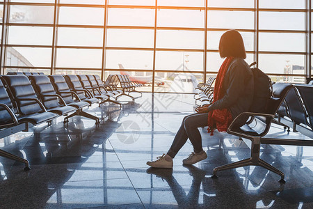 在机场休息室等候航班的携带背包的女旅游图片