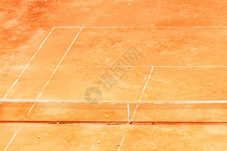 在红土网球场橙色的网球红色黄球图片