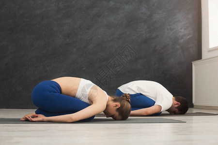 年轻运动夫妇在健身室的垫子上一起做有氧锻炼活动图片