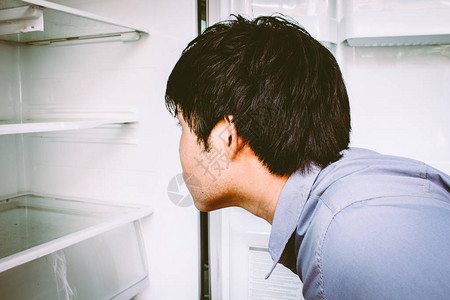 饥饿的人打开冰箱背景图片